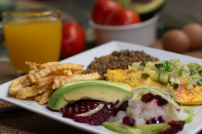 kawsay-amazon-jungle-tours-dining-food Traditional Peruvian jungle meal with yellow rice peppers plantain and chicken served on a plate, highlighting Amazon rainforest tours culinary experience